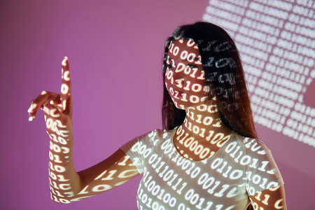 Binary machine code. Beautiful young woman is in projector neon lights in the studio.
