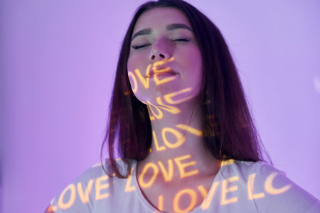 Conception of love. Beautiful young woman is in projector neon lights in the studio.