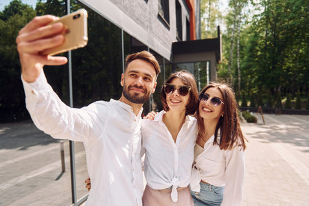 Making a selfie. Three friends having great weekend outdoors together.