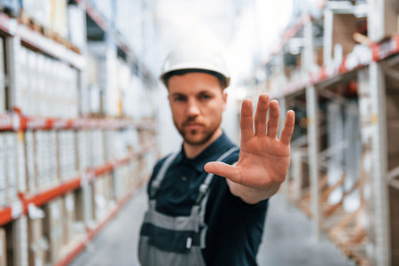 Stop here. No pass. Employee in uniform is working in the storage at daytime.