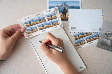 TERNOPIL, UKRAINE - June 28: Postage stamps "Russian warship... done". Woman writing letter.のeditorial素材
