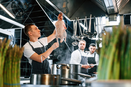 Conception of cooperation. Kitchen workers is together preparing the food.