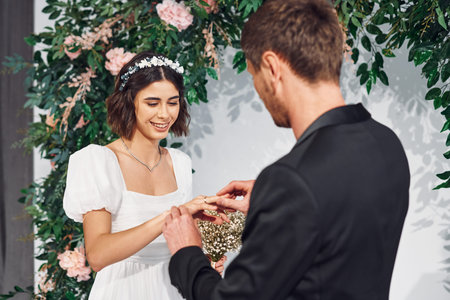 Wearing the rings. Beautiful bride with his fiance is on the wedding.