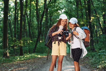 Standing on the footpath. Two girls is in the forest having a leisure activity, discovering new places.の写真素材