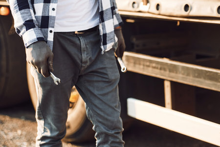 Close up view. Young truck driver is with his vehicle at daytime.の写真素材