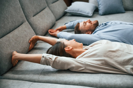 Laying down together. Couple choosing the sofa and bed in the store.の写真素材