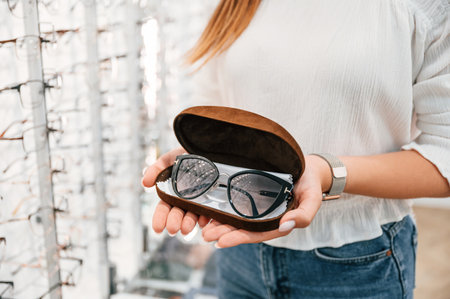 Holding case with glasses. Woman is in the store. Close up view.の写真素材