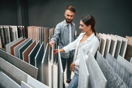 Different materials and colors. Woman and man is in the store of goods for the home.の写真素材