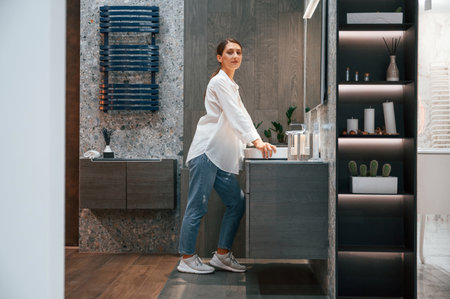 Side view. Pretty young woman is in the store of goods for the home.の写真素材