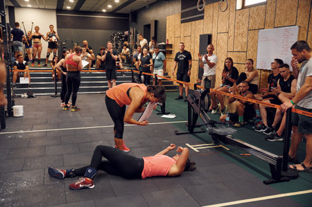 Ternopil, Ukraine - August 20, 2022: Sportive competition in the gym. Woman laying down on the floor, exhausted.のeditorial素材