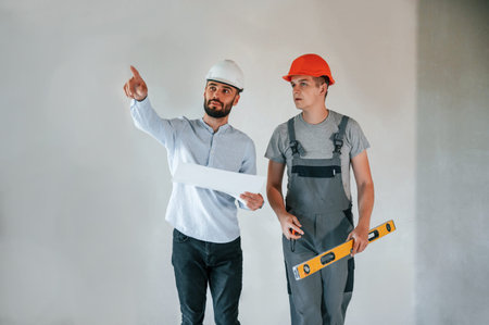 Two men is making repairs in the apartment together.