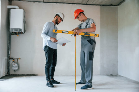 Two men is making repairs in the apartment together.