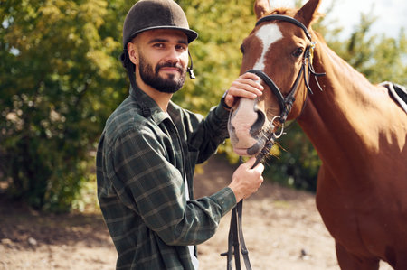 Young man with a horse is outdoors.の写真素材