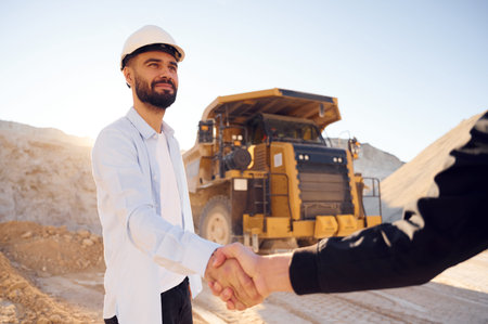 Quarry worker making a deal with colleague. Shaking hands.