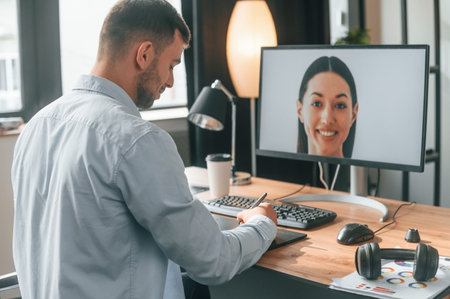 Retouching portrait of woman. Designer is sitting by the computer and using graphics tablet with...