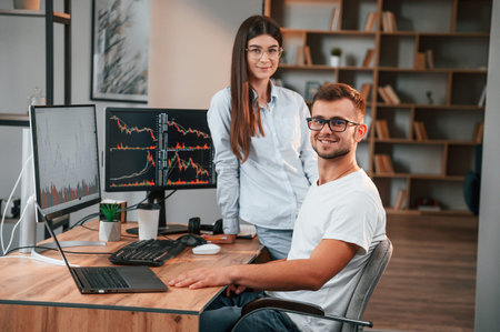 Two stock brokers is working together in the office with finances.