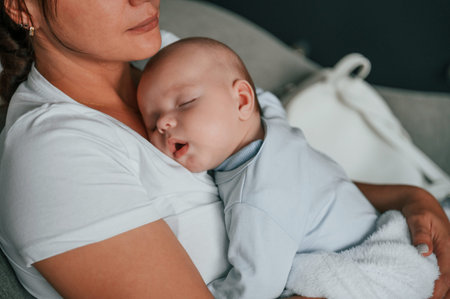 Close up view of cute baby that sleeping on the mother's chest.