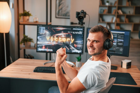 Finally, a victory. Young man playing and streaming the first person shooter game.