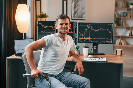 Young stock broker is working in the office by using computer.
