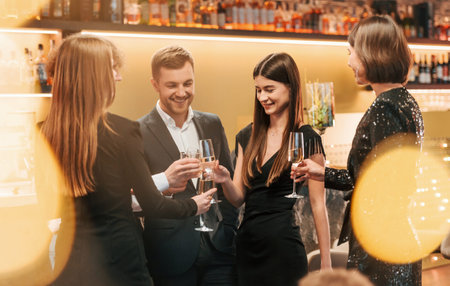 Group of people in elegant clothes are in the restaurant celebrating event.