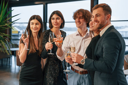 Smiling for the camera. Group of people in beautiful elegant clothes are celebrating New Year...