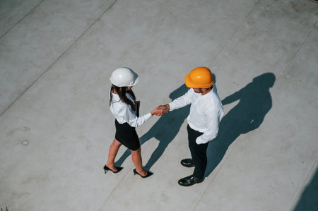 Successful deal, doing handshake. Man with woman are working on the construction project together...
