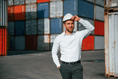 Beautiful portrait. Male worker is on the location with containers.