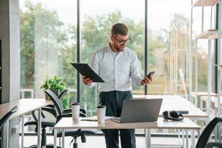 Angry, feeling tired and bad. Man in formal clothes is working in the modern office.