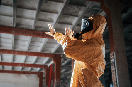Nuclear explosion. Man dressed in chemical protection suit in the ruins of the post apocalyptic...
