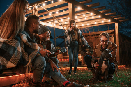 Evening time. Group of people is spending time together on the backyard.の写真素材
