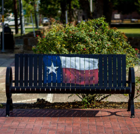 public park bench with Texas flag painted on it in Montgomery, TX.の写真素材