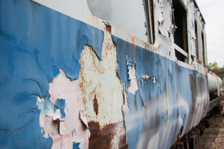 Old trains are parked outdoors where they are exposed to the heat of sunlight and rain, resulting in cracking and rusting.の写真素材