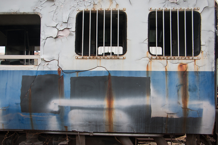 Old trains are parked outdoors where they are exposed to the heat of sunlight and rain, resulting in cracking and rusting.の写真素材