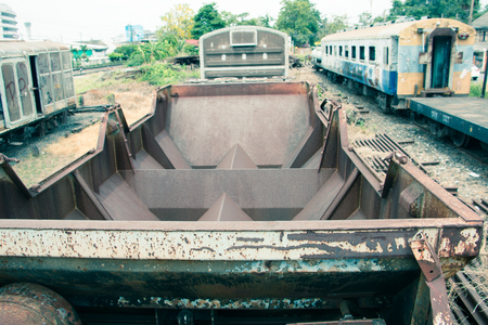 Old trains are parked outdoors where they are exposed to the heat of sunlight and rain, resulting in cracking and rusting.の写真素材