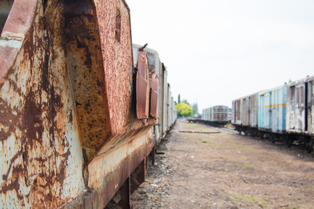 Old trains are parked outdoors where they are exposed to the heat of sunlight and rain, resulting in cracking and rusting.の写真素材