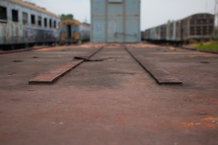 Old trains are parked outdoors where they are exposed to the heat of sunlight and rain, resulting in cracking and rusting.の写真素材
