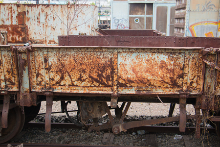 Old trains are parked outdoors where they are exposed to the heat of sunlight and rain, resulting in cracking and rusting.の写真素材