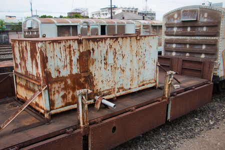 Old trains are parked outdoors where they are exposed to the heat of sunlight and rain, resulting in cracking and rusting.の写真素材