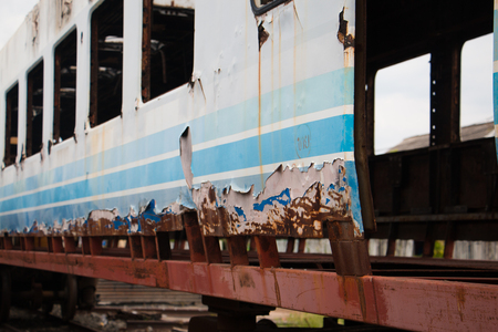 Old trains are parked outdoors where they are exposed to the heat of sunlight and rain, resulting in cracking and rusting.の写真素材