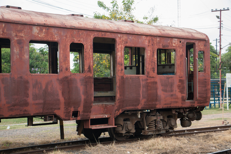 Old trains are parked outdoors where they are exposed to the heat of sunlight and rain, resulting in cracking and rusting.の写真素材