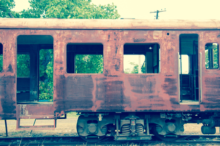Old trains are parked outdoors where they are exposed to the heat of sunlight and rain, resulting in cracking and rusting.の写真素材