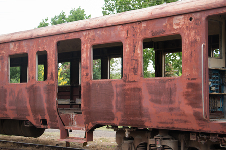 Old trains are parked outdoors where they are exposed to the heat of sunlight and rain, resulting in cracking and rusting.の写真素材
