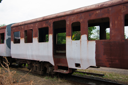 Old trains are parked outdoors where they are exposed to the heat of sunlight and rain, resulting in cracking and rusting.の写真素材