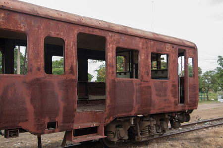 Old trains are parked outdoors where they are exposed to the heat of sunlight and rain, resulting in cracking and rusting.の写真素材