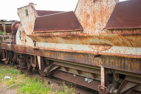 Old trains are parked outdoors where they are exposed to the heat of sunlight and rain, resulting in cracking and rusting.の写真素材