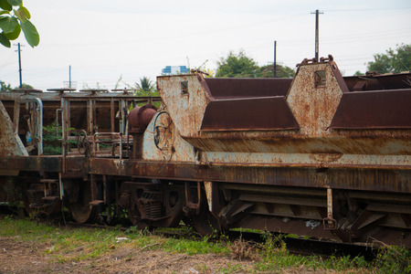 Old trains are parked outdoors where they are exposed to the heat of sunlight and rain, resulting in cracking and rusting.の写真素材