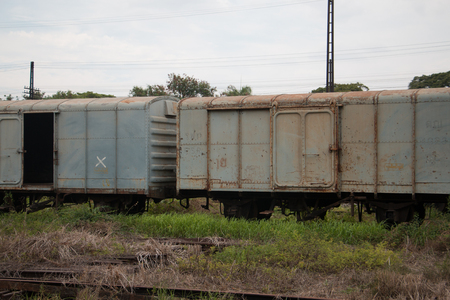 Old trains are parked outdoors where they are exposed to the heat of sunlight and rain, resulting in cracking and rusting.の写真素材