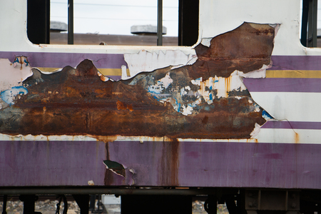 Old trains are parked outdoors where they are exposed to the heat of sunlight and rain, resulting in cracking and rusting.の写真素材