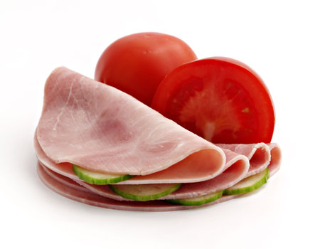 slices of ham with cucumber and tomato isolated on the white backgroundの写真素材