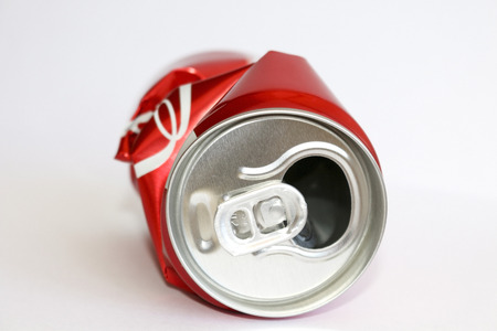 Crumpled empty blank soda or beer for garbage, on a white background.Crumpled aluminum can.Jar red.の写真素材
